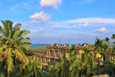 Panoramic view of coconut trees and buildings against sky