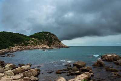 Rocks by sea against sky