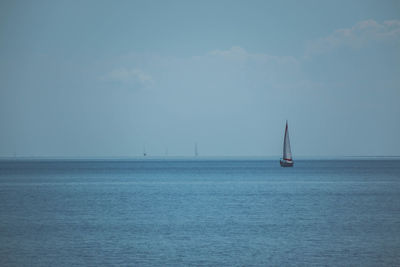 Sailboat sailing on sea against sky