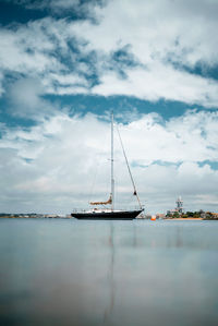 Sailboat in sea against sky