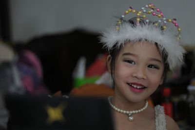 Portrait of smiling girl wearing headdress at home