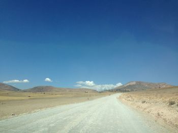Empty road along countryside landscape