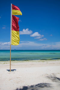 Scenic view of beach against blue sky