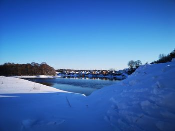 Scenic view of snow against clear blue sky