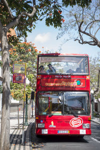 Red truck on road in city against sky