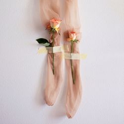 Low section of woman standing by flowering plant