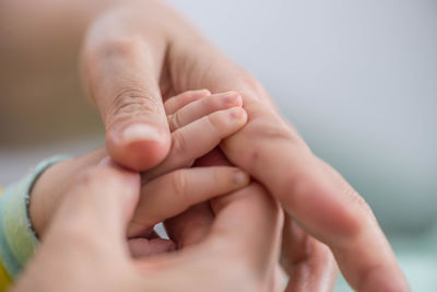 Cropped image of parent holding baby hands