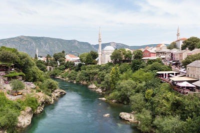 River amidst buildings in town against sky