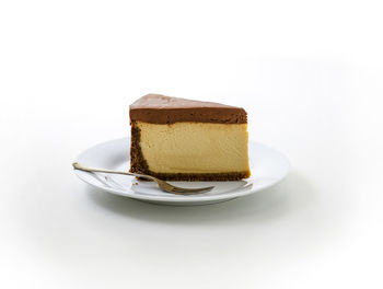 Close-up of cake in plate against white background