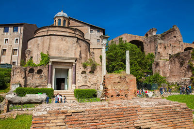 Tourists visiting the ancient romulus temple at the roman forum in rome