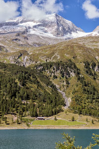 Scenic view of lake by mountains against sky