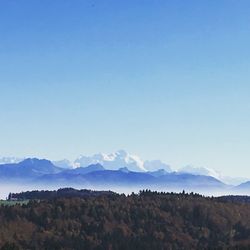 Scenic view of mountains against blue sky