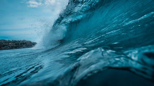 Sea waves splashing against blue sky