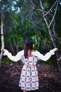 Full length of woman standing by tree