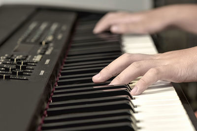 Cropped hands playing piano 