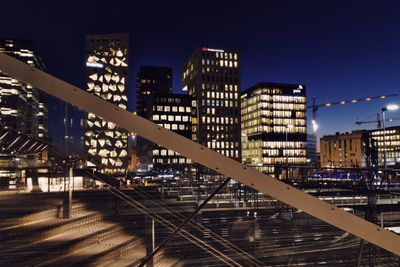 Illuminated cityscape against clear sky at night