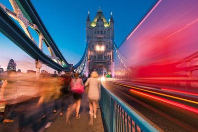 People walking on tower bridge at dawn