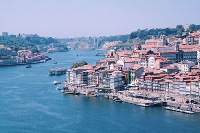 Aerial view of city by sea against clear sky