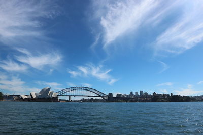 View of bridge over city against cloudy sky