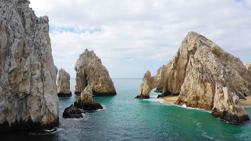 Panoramic view of rocks and sea against sky