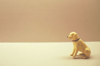Close-up of figurine sitting against gray background