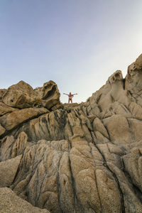 Low angle view of rocks on mountain against clear sky