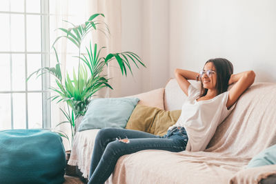 Carefree woman relaxing on sofa at home