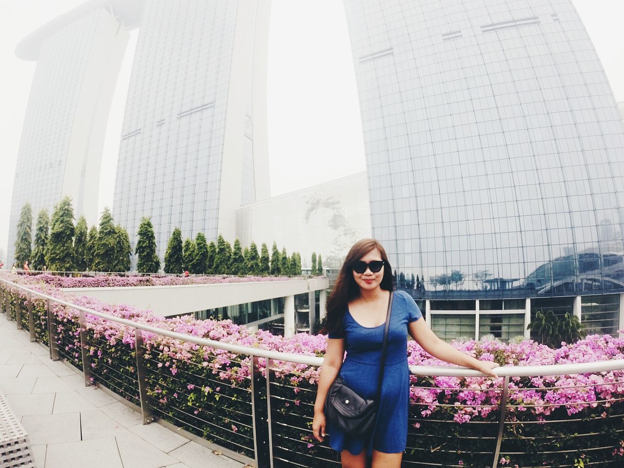 young adult, lifestyles, architecture, built structure, building exterior, casual clothing, person, leisure activity, looking at camera, standing, portrait, young women, smiling, front view, city, waist up, clear sky