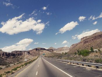 Road passing through mountains against sky