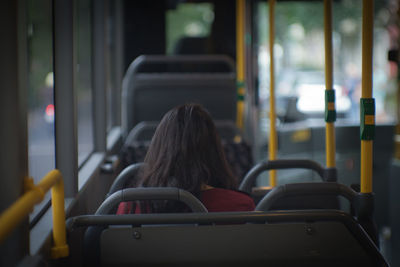 Rear view of woman sitting in bus