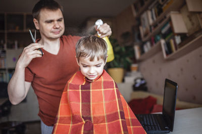 Full length of father and boy using smart phone