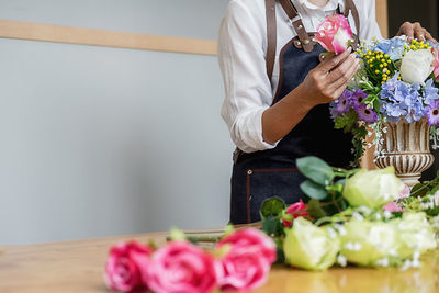 Midsection of woman with rose bouquet