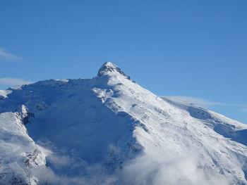 Scenic view of snowcapped mountains against clear blue sky