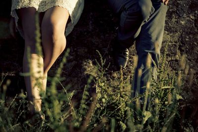 Low section of woman standing on field