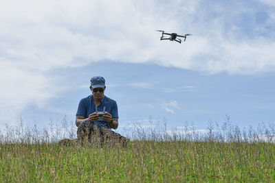 Low angle view of airplane flying over field against sky