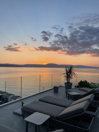 Scenic view of swimming pool by sea against sky during sunset