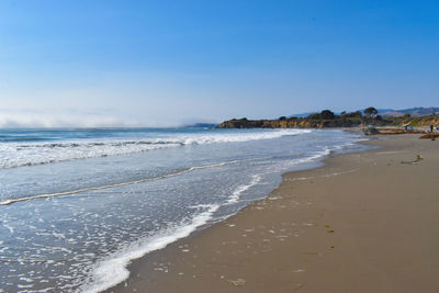 Pretty vacation day at sandy beach with calm water waves gently coming ashore miles of sandy beach