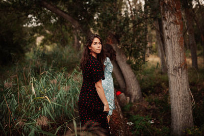 Full length of young lesbian couple standing in forest