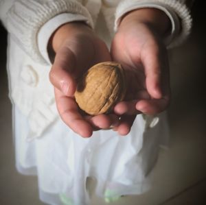 Midsection of woman holding nut