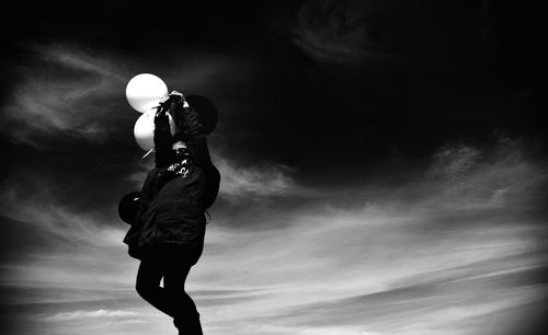 Low angle view of man against cloudy sky