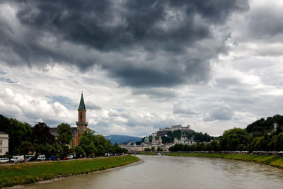 View of river amidst buildings against sky