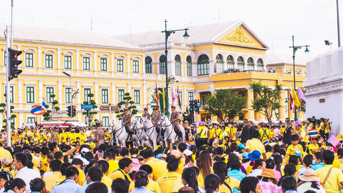 People on street against buildings in city