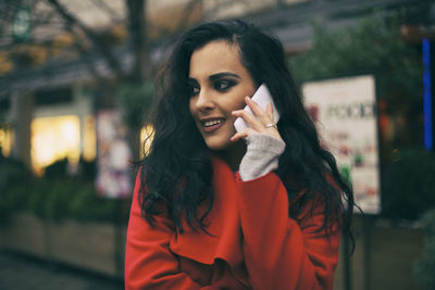 Young woman talking on mobile phone in city