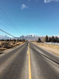 Empty road by mountain against sky