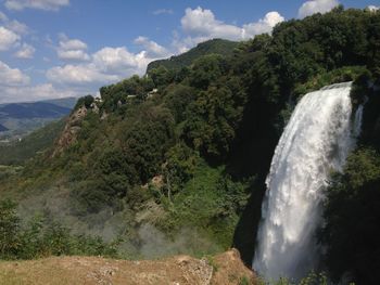 Scenic view of waterfall against sky