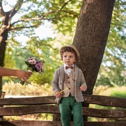 Cute boy standing against tree trunk