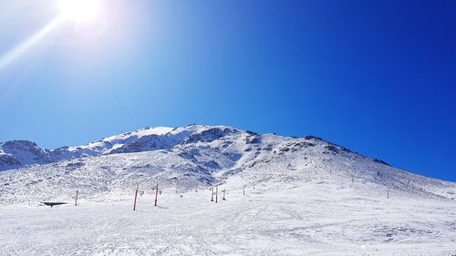 Scenic view of snowcapped mountains against clear blue sky