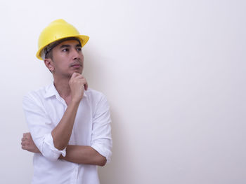 Mid adult man looking away against white background