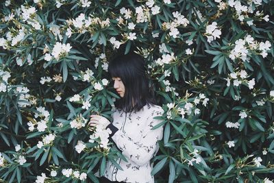 Woman standing by flowering plants