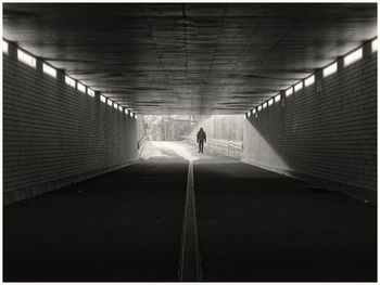 Rear view of man walking on footbridge